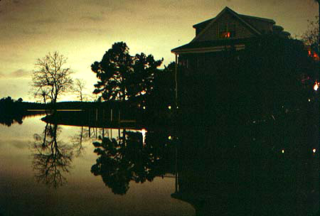 House on Lake at sunset - Light in window at night